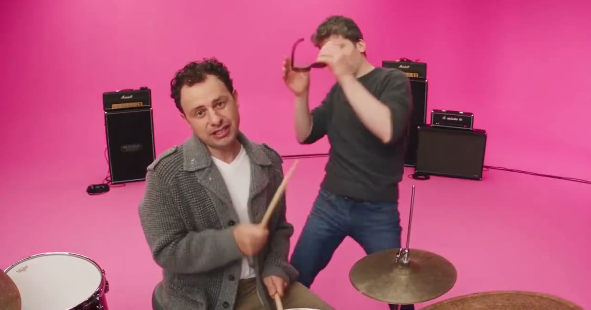 APT AI video example: a short pink-studio preview with two people. AI-generated, not the APT. film.