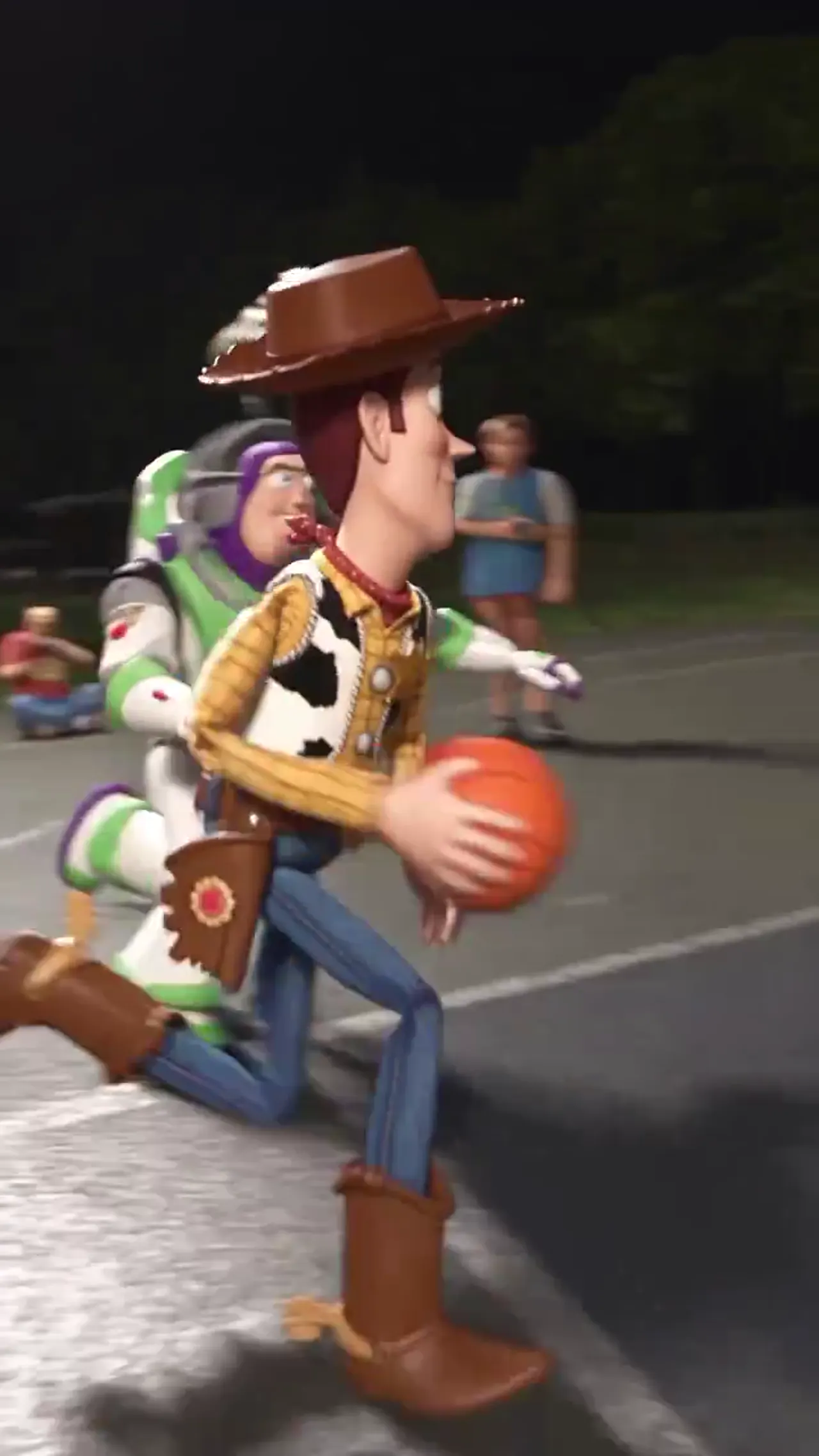 Woody drives past Buzz with the basketball