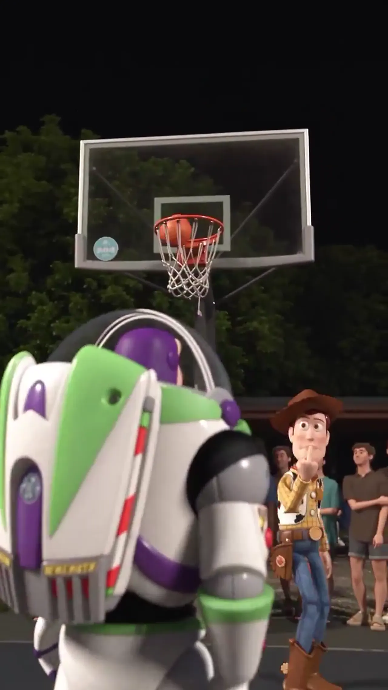 The ball drops through the net as Woody points at the camera