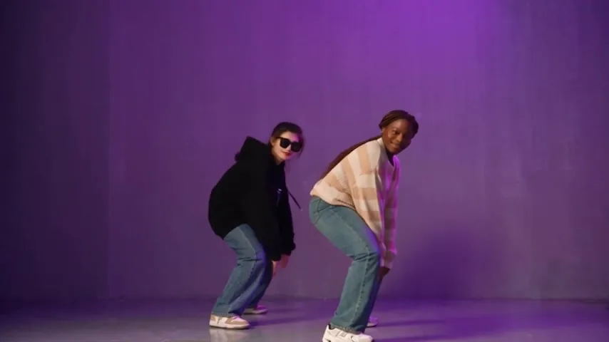 Both dancers lean into a forward crouch